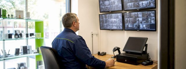 Responsabilul de securitate verifică și reglează monitoarele sistemului de supraveghere din interiorul clădirii.